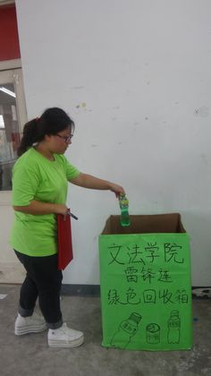 同学把空瓶放入绿色回收箱.jpg