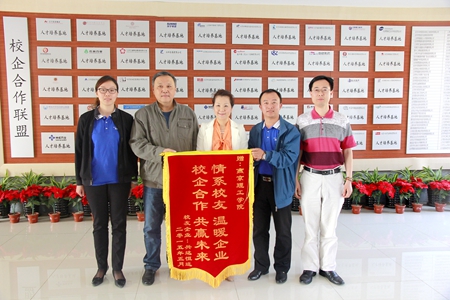 校友齐岳（右二）向我校赠送锦旗.JPG