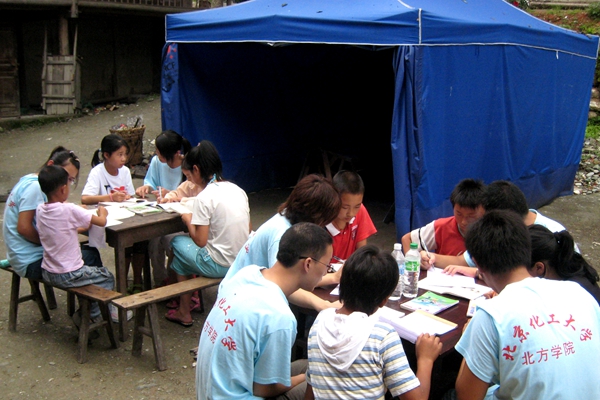 图为2008年，燕京理工学院大学生在帐篷外给小学生们补习功课.jpg